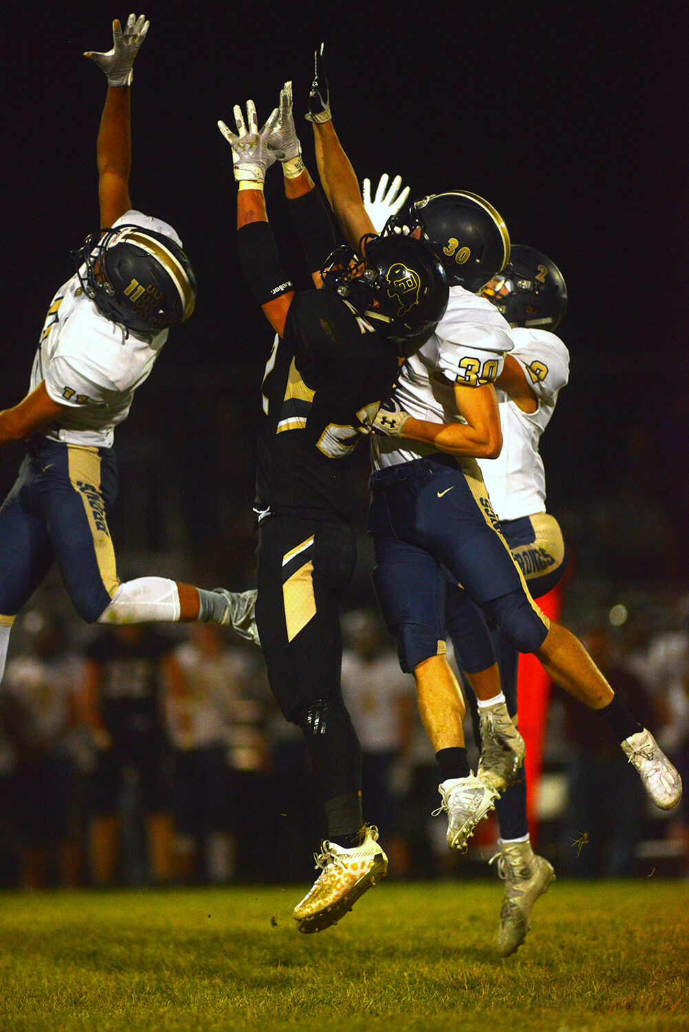 A Buffalo receiver and Cody defenders stretch for a pass